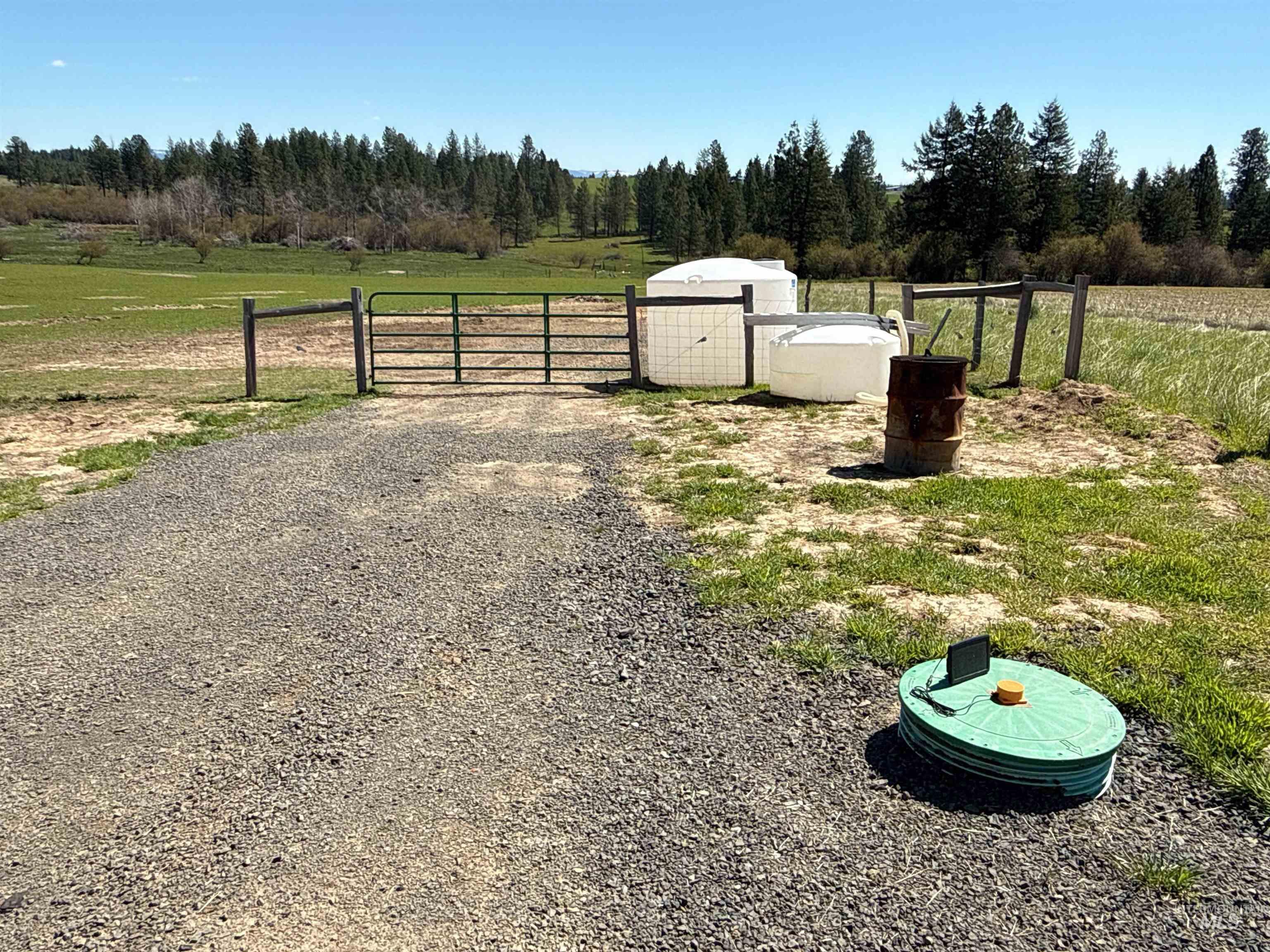 1254 Stuart Road Orofino, ID 83544 - Photo 23 of 48 Gravel driveway entry with a metal gate and wooden fence posts