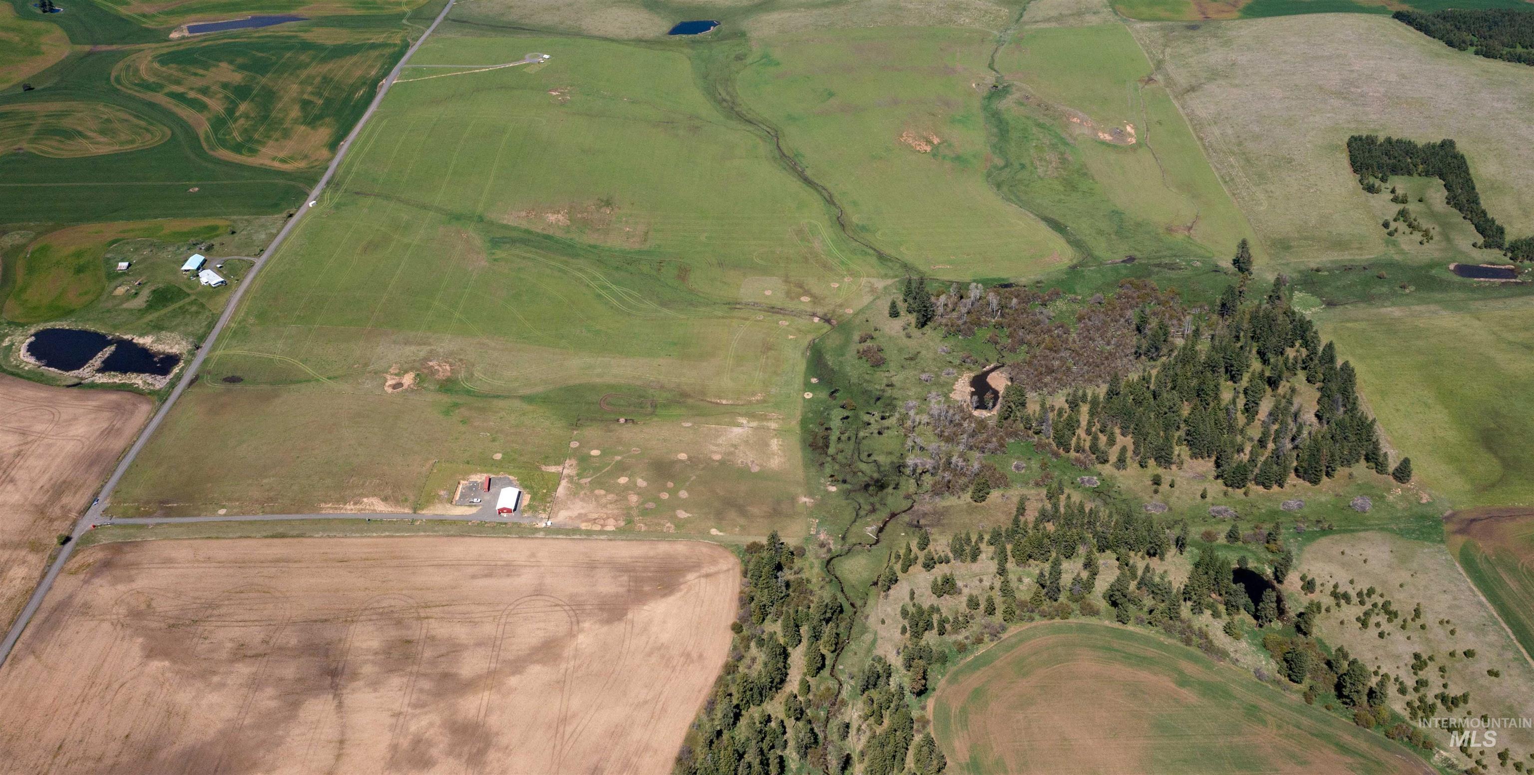 1254 Stuart Road Orofino, ID 83544 - Photo 47 of 48 Expansive aerial view of rural property featuring varied terrain, including cultivated fields, grasslands, and forested areas