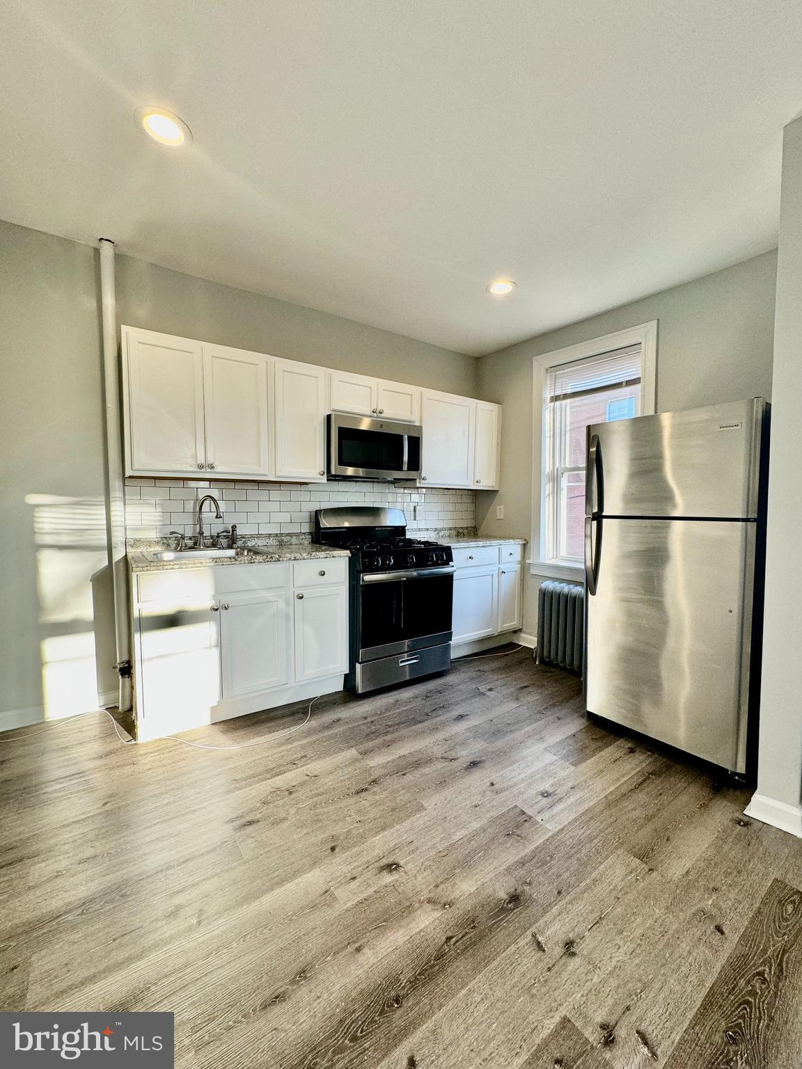 5388 Hazelhurst Street, Unit 3F Philadelphia, PA 19131 - Photo 1 of 6 a kitchen with a refrigerator and a stove top oven