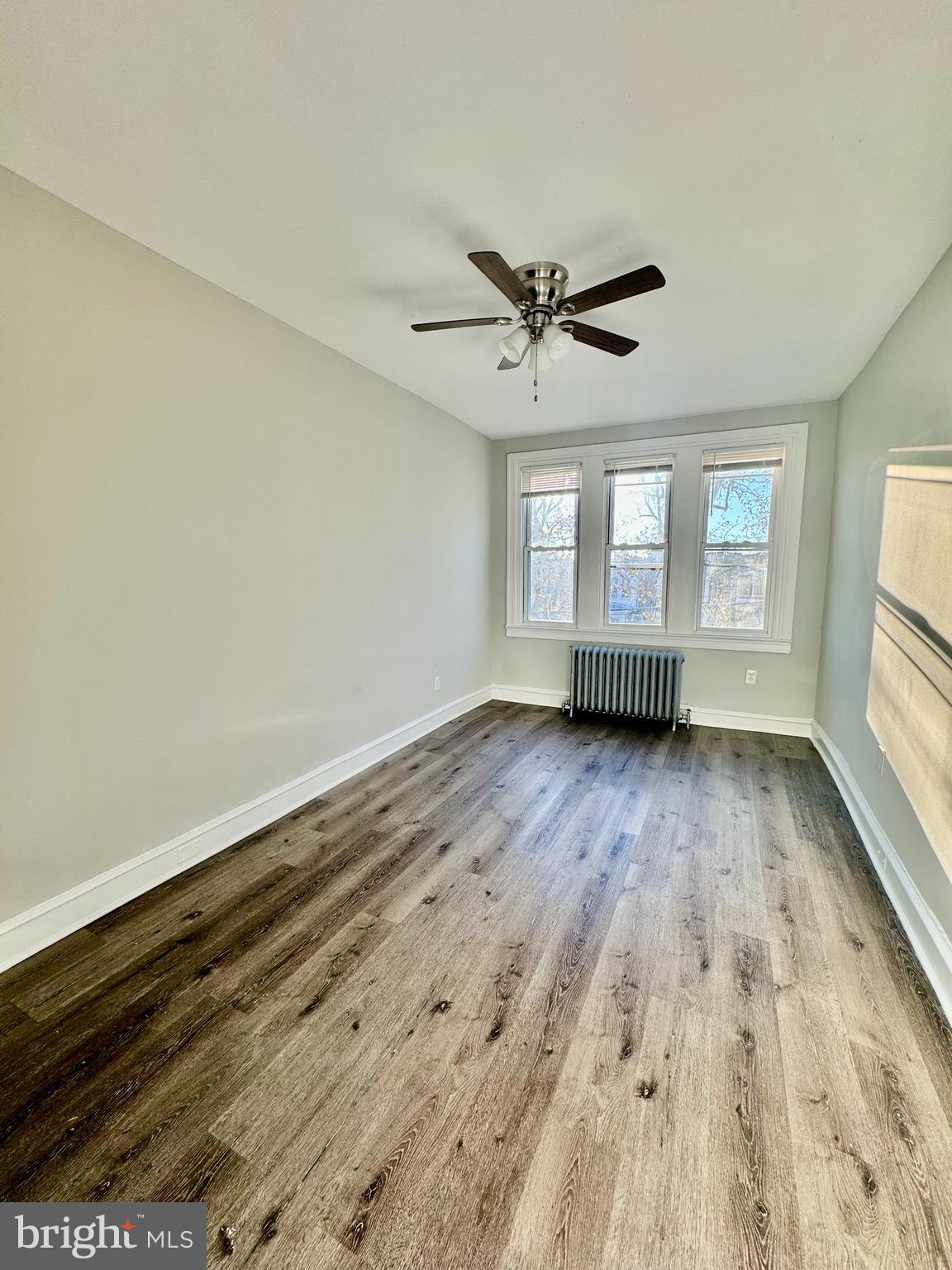 5388 Hazelhurst Street, Unit 3F Philadelphia, PA 19131 - Photo 5 of 6 an empty room with wooden floor and windows