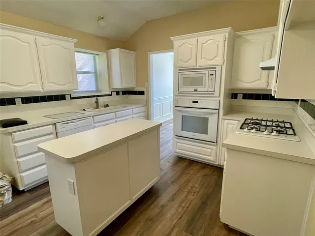 a kitchen with cabinets appliances and a counter space