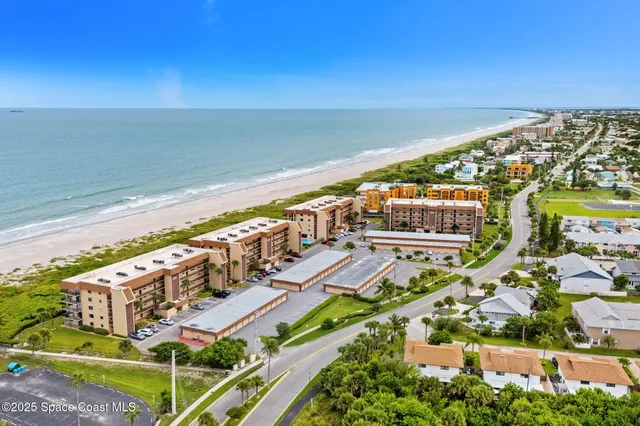 an aerial view of residential houses with outdoor space and trees