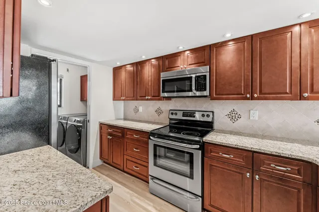 a kitchen with stainless steel appliances a stove microwave and refrigerator