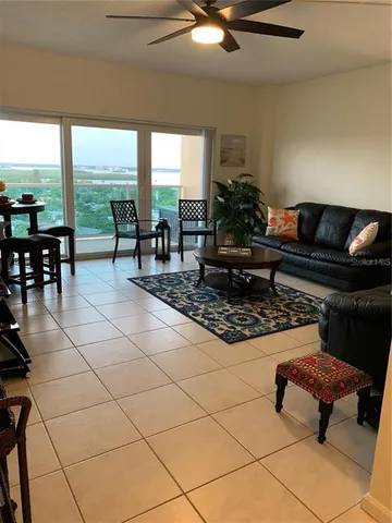 a living room with patio furniture and a floor to ceiling window