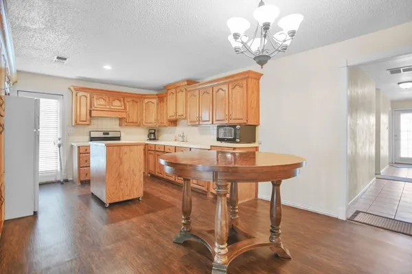 a kitchen with stainless steel appliances a table chairs and a refrigerator