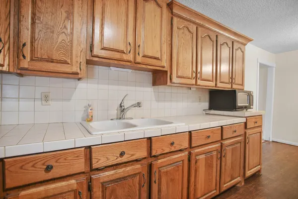 a kitchen with granite countertop white cabinets and sink