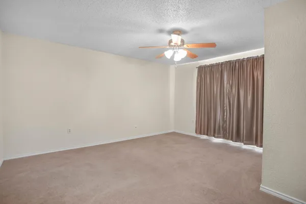 an empty room with a chandelier fan