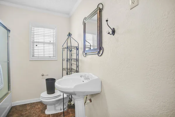 a bathroom with a toilet a sink and mirror