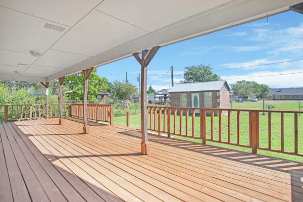 a view of balcony with wooden floor and fence
