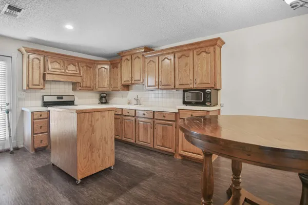 a kitchen with stainless steel appliances granite countertop a stove a sink dishwasher and a refrigerator