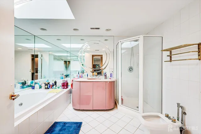 a bathroom with a tub shower sink and mirror
