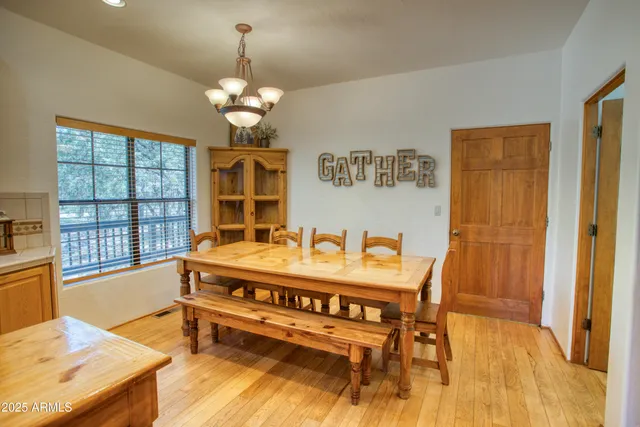 a view of a dining room with furniture a chandelier and wooden floor