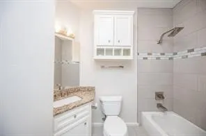 a bathroom with a granite countertop sink toilet and shower
