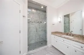a bathroom with a granite countertop sink a mirror and shower