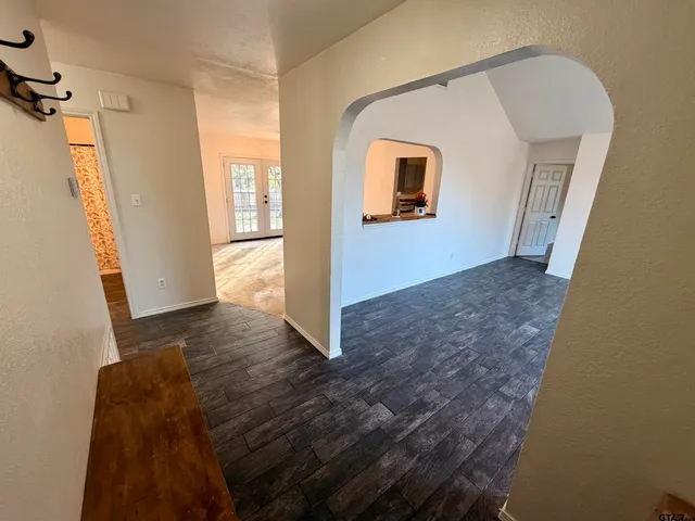 a view of a hallway with wooden floor and stairs