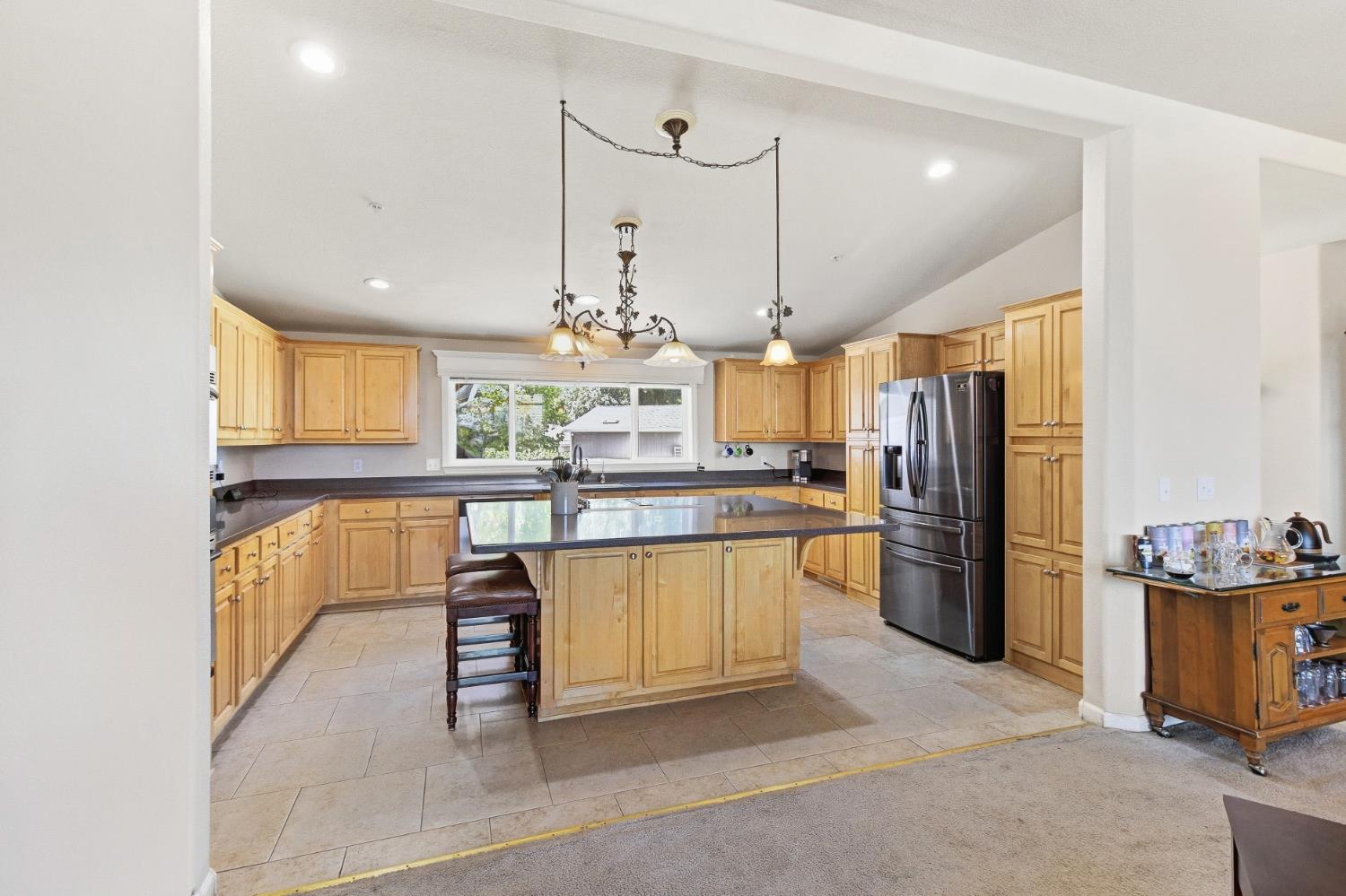 12390 Hobday Road Wilton, CA 95693 - Photo 16 of 92 a kitchen with stainless steel appliances kitchen island granite countertop a refrigerator a stove and a sink with cabinets