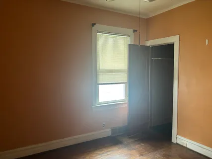 an empty room with windows and closet