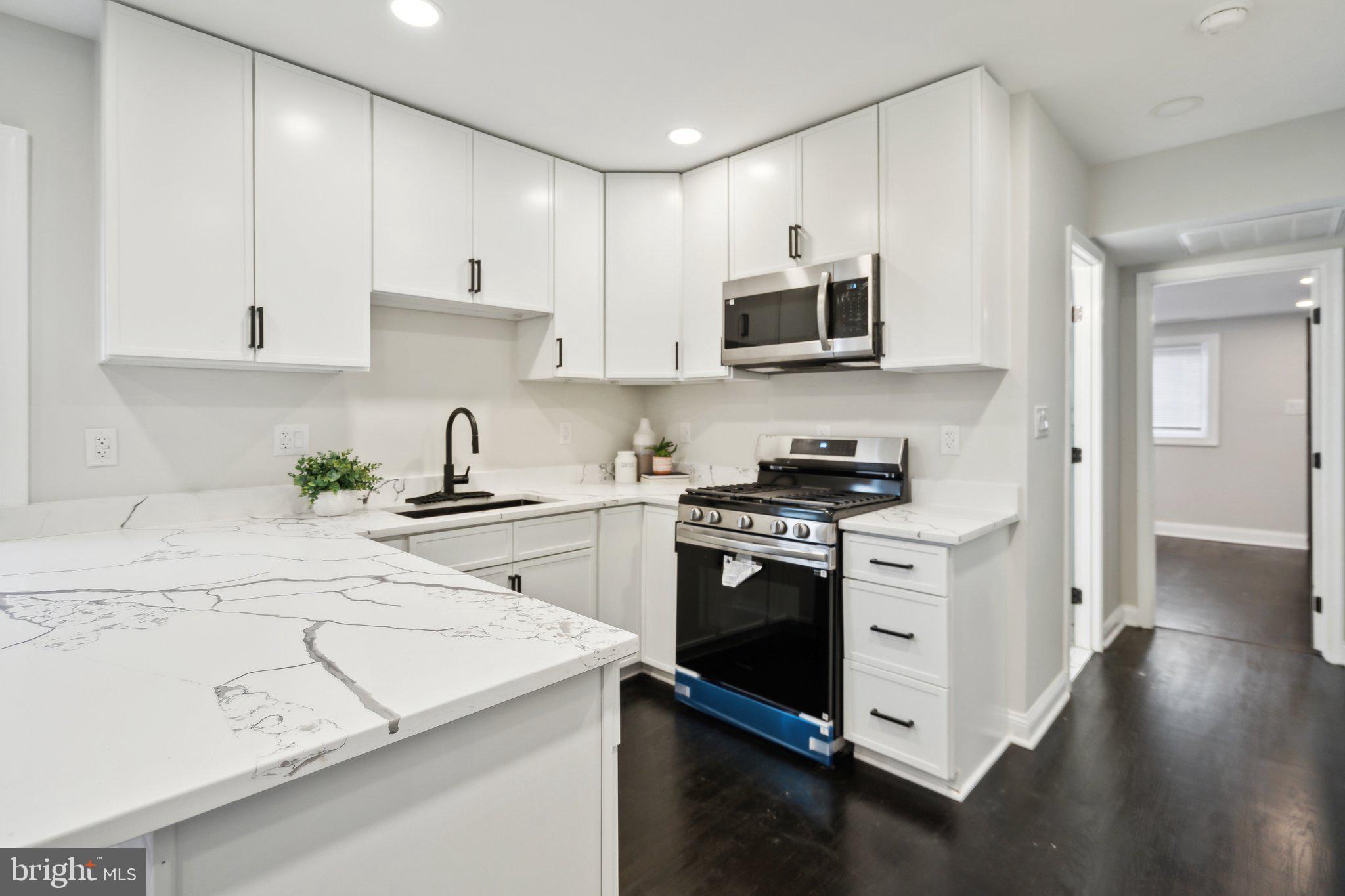 421 Dateleaf Avenue Capitol Heights, MD 20743 - Photo 14 of 39 a kitchen with stainless steel appliances granite countertop a stove a sink and white cabinets