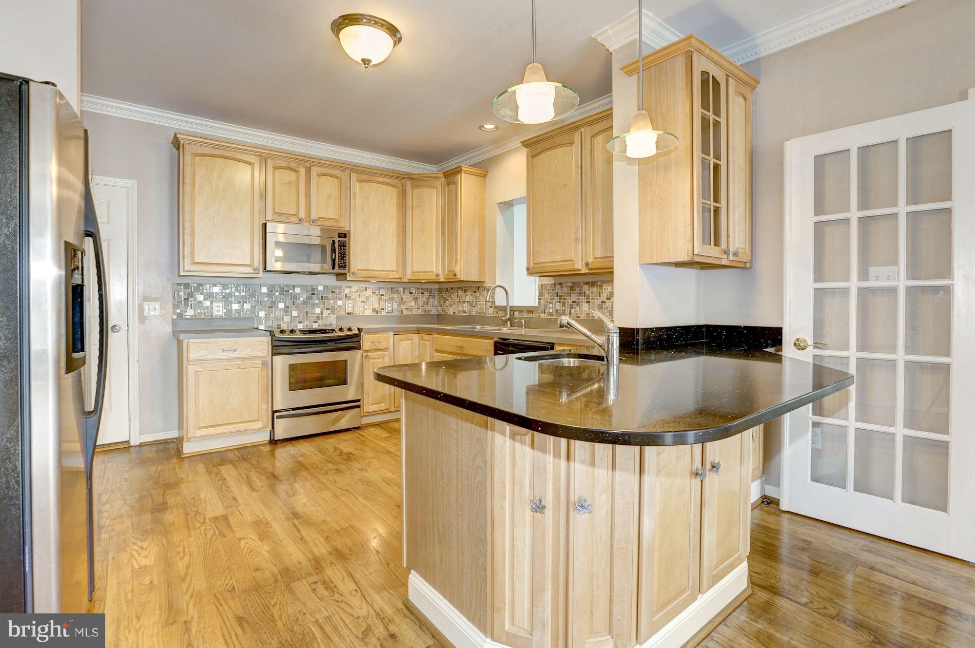 1407 Jasper Street Silver Spring, MD 20902 - Photo 3 of 21 a kitchen with stainless steel appliances granite countertop a sink a stove and a refrigerator