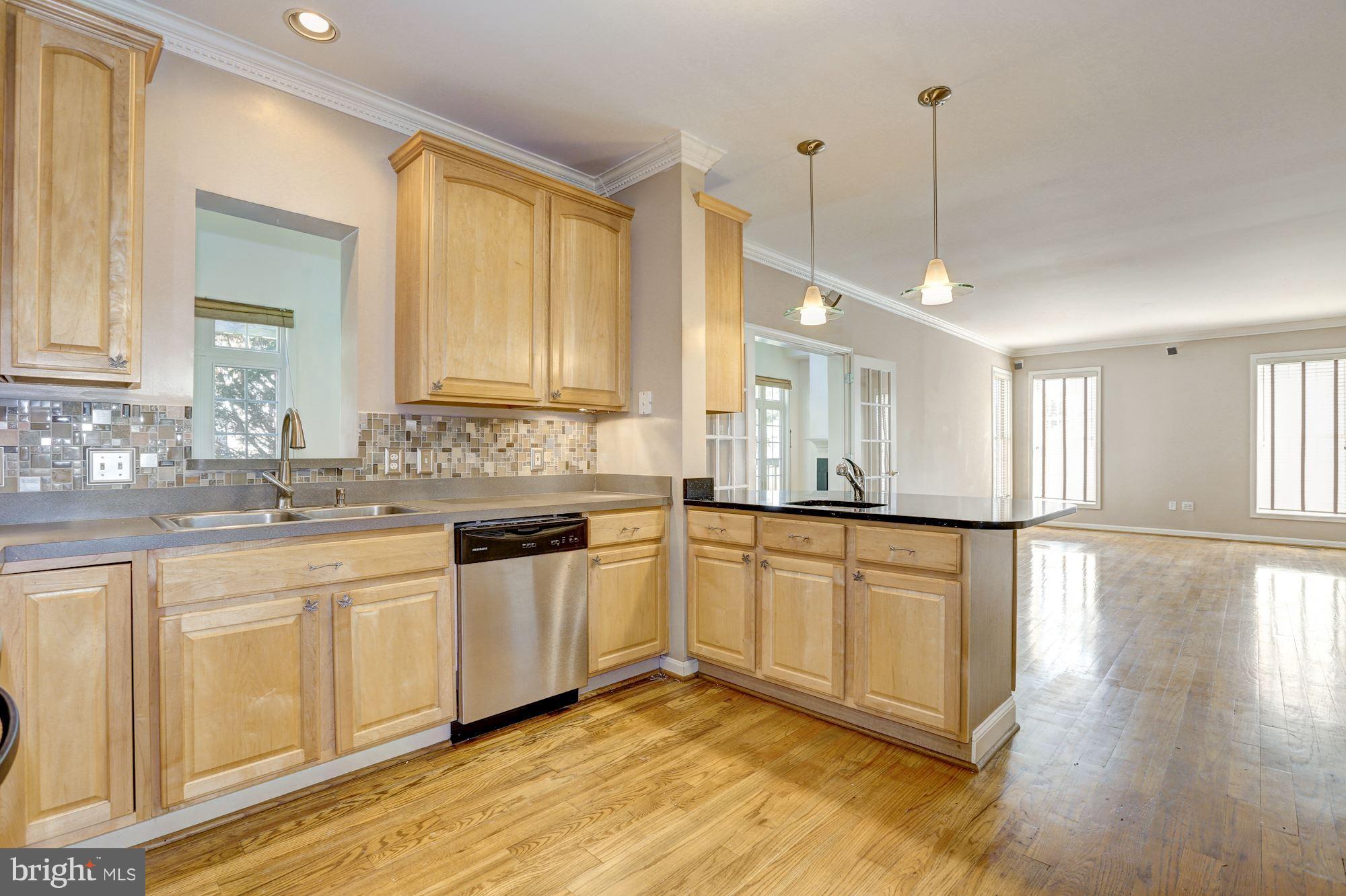 1407 Jasper Street Silver Spring, MD 20902 - Photo 4 of 21 a kitchen with stainless steel appliances granite countertop a stove a sink and white cabinets with wooden floors
