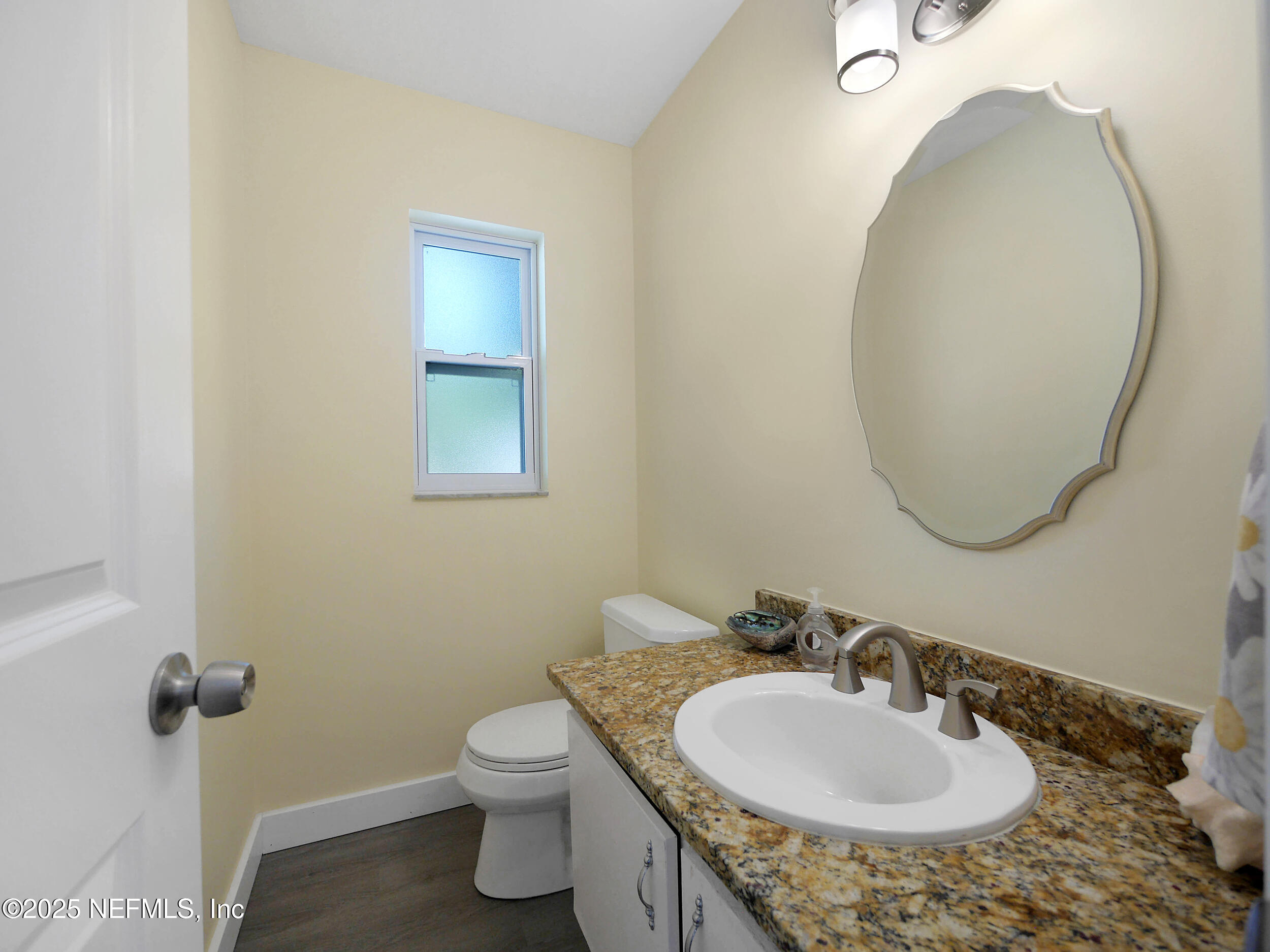 971 Viscaya Boulevard St. Augustine, FL 32086 - Photo 34 of 47 a bathroom with a sink a toilet and a mirror