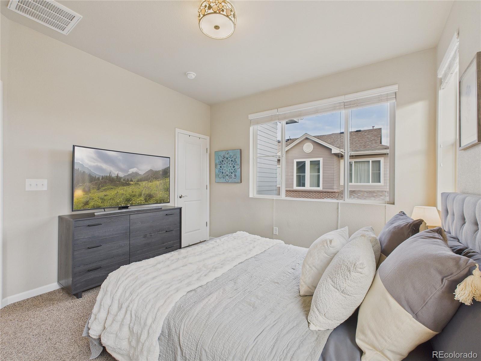 15516 West 64th Loop, Unit F Arvada, CO 80007 - Photo 5 of 23 a bedroom with a bed and a window