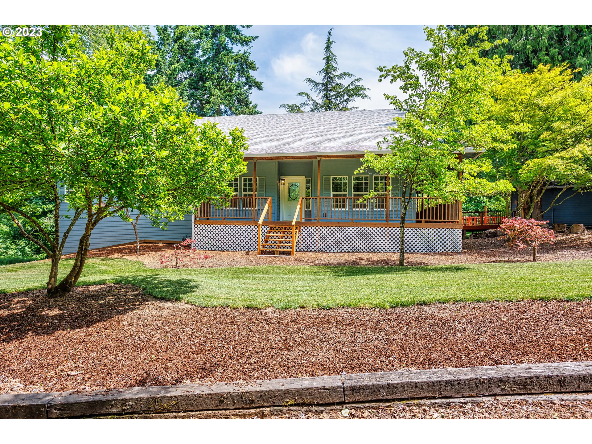 a front view of a house with a yard and a tree