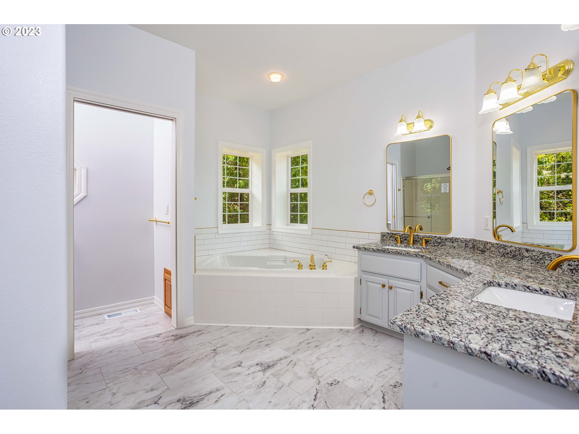280 South 15th Court Ridgefield, WA 98642 - Photo 16 of 44 a bathroom with a granite countertop sink a bathtub a mirror and vanity