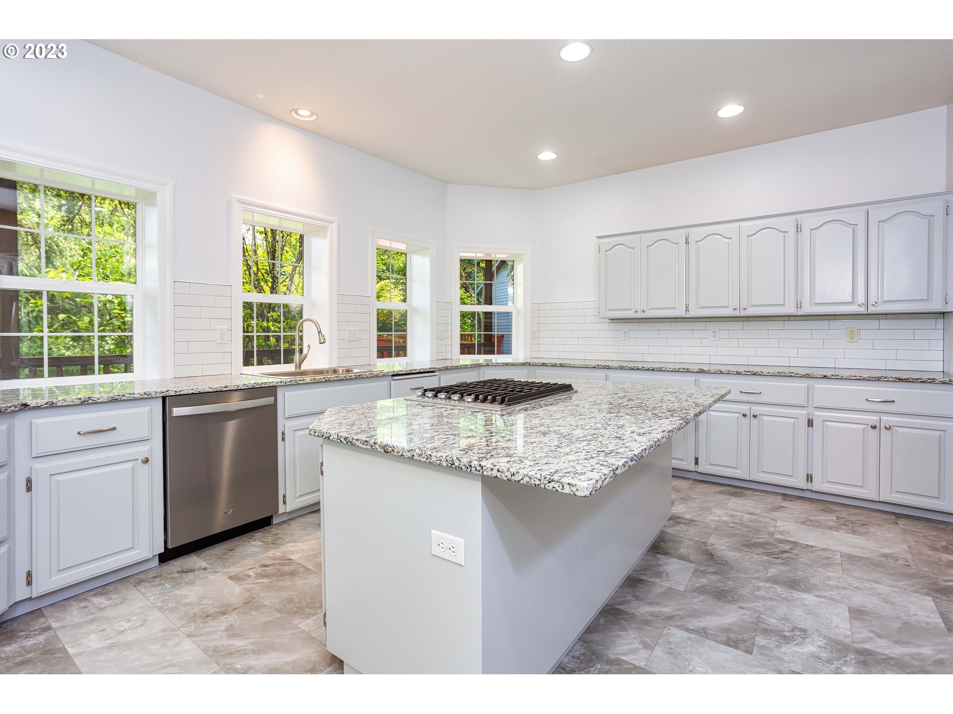 280 South 15th Court Ridgefield, WA 98642 - Photo 7 of 44 a kitchen with granite countertop a sink stainless steel appliances and white cabinets