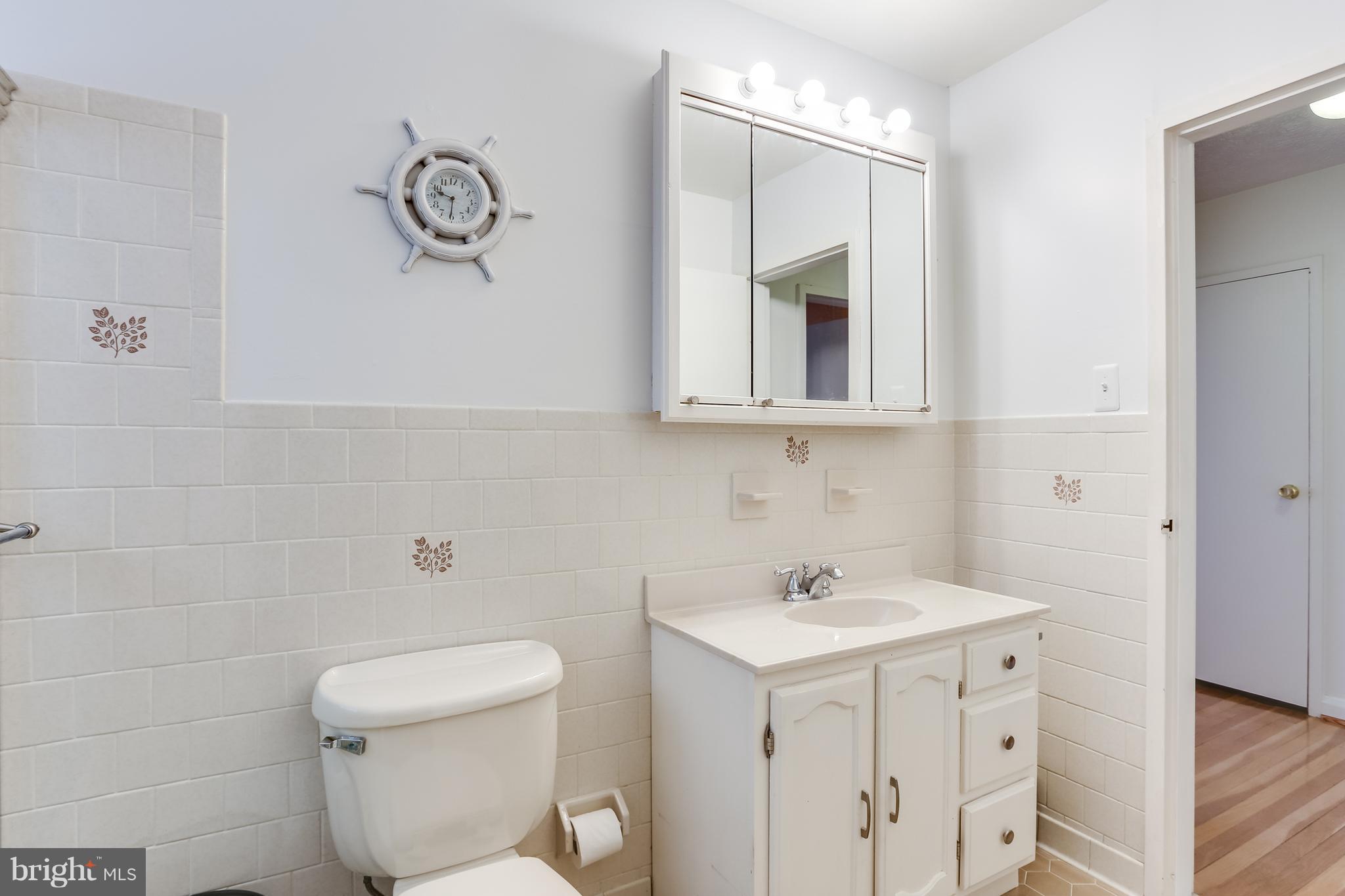 936 Vanderwood Road Baltimore, MD 21228 - Photo 15 of 27 a bathroom with a toilet sink and mirror