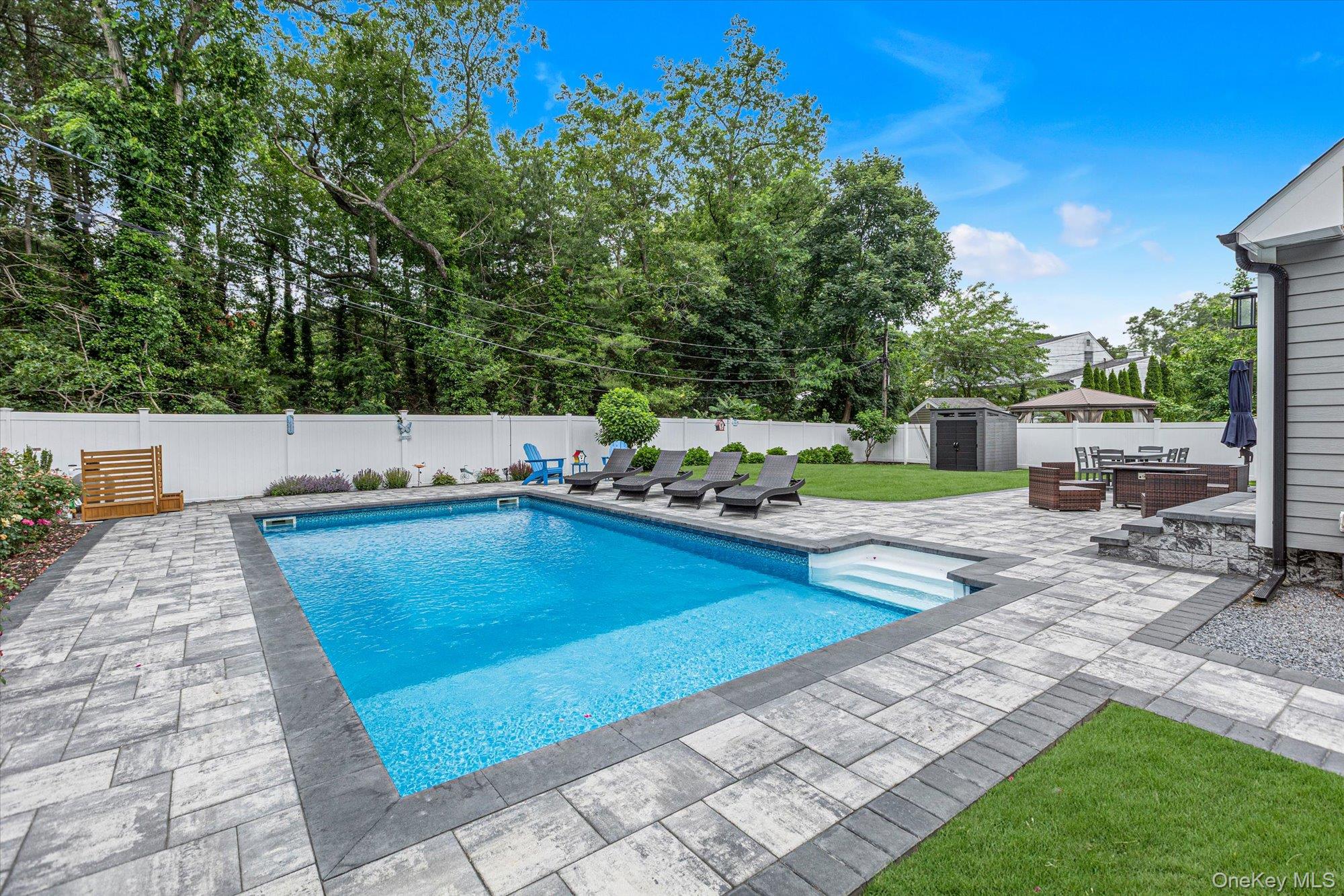 31 Apple Lane Commack, NY 11725 - Photo 23 of 28 In-ground pool with beautiful paved patio surround and decorative landscaping.