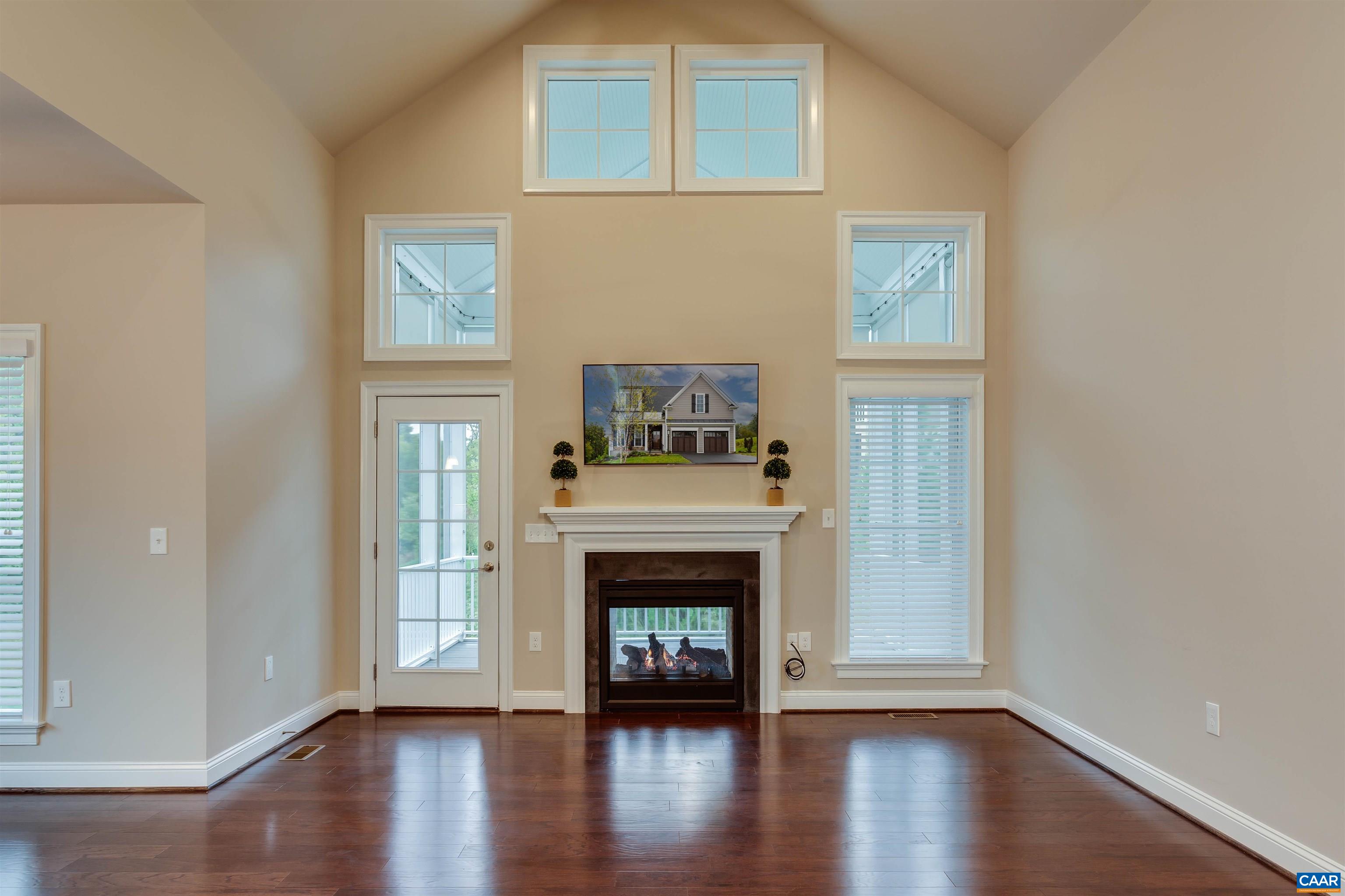 596 Drumin Road Keswick, VA 22947 - Photo 15 of 57 an empty room with wooden floor a fireplace and windows