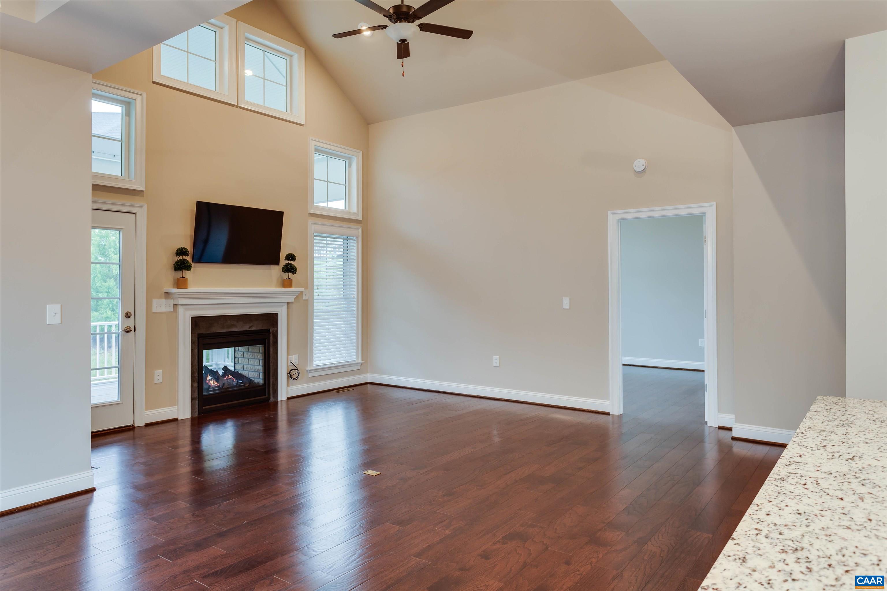 596 Drumin Road Keswick, VA 22947 - Photo 18 of 57 an empty room with wooden floor fireplace and windows