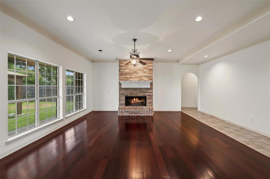 5607 Ranger Drive Rockwall, TX 75032 - Photo 13 of 40 Spacious living area featuring rich wood-finish flooring and a brick fireplace with a white mantel