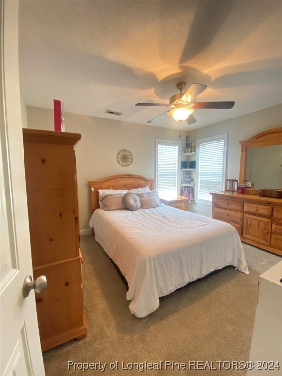 2729 H Bullard Road Hope Mills, NC 28348 - Photo 7 of 15 a bedroom with a bed and a chandelier