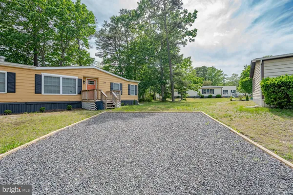 a front view of a house with a yard and trees