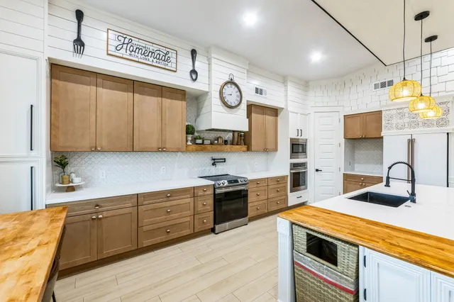 a kitchen with a sink dishwasher and a clock on the wall