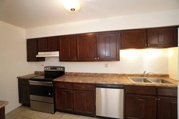 a kitchen with granite countertop a sink cabinets and stainless steel appliances