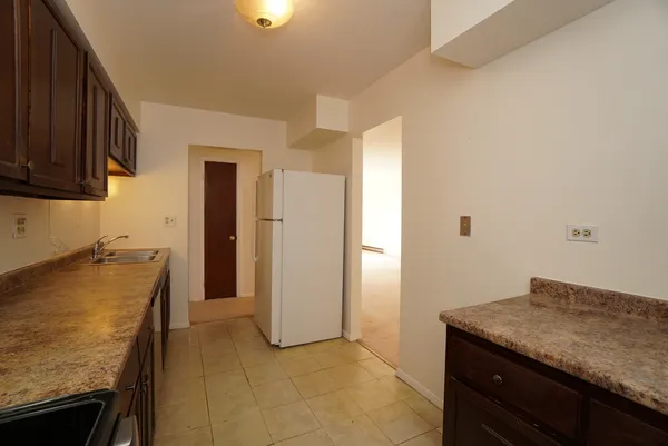 a kitchen with granite countertop cabinets and refrigerator