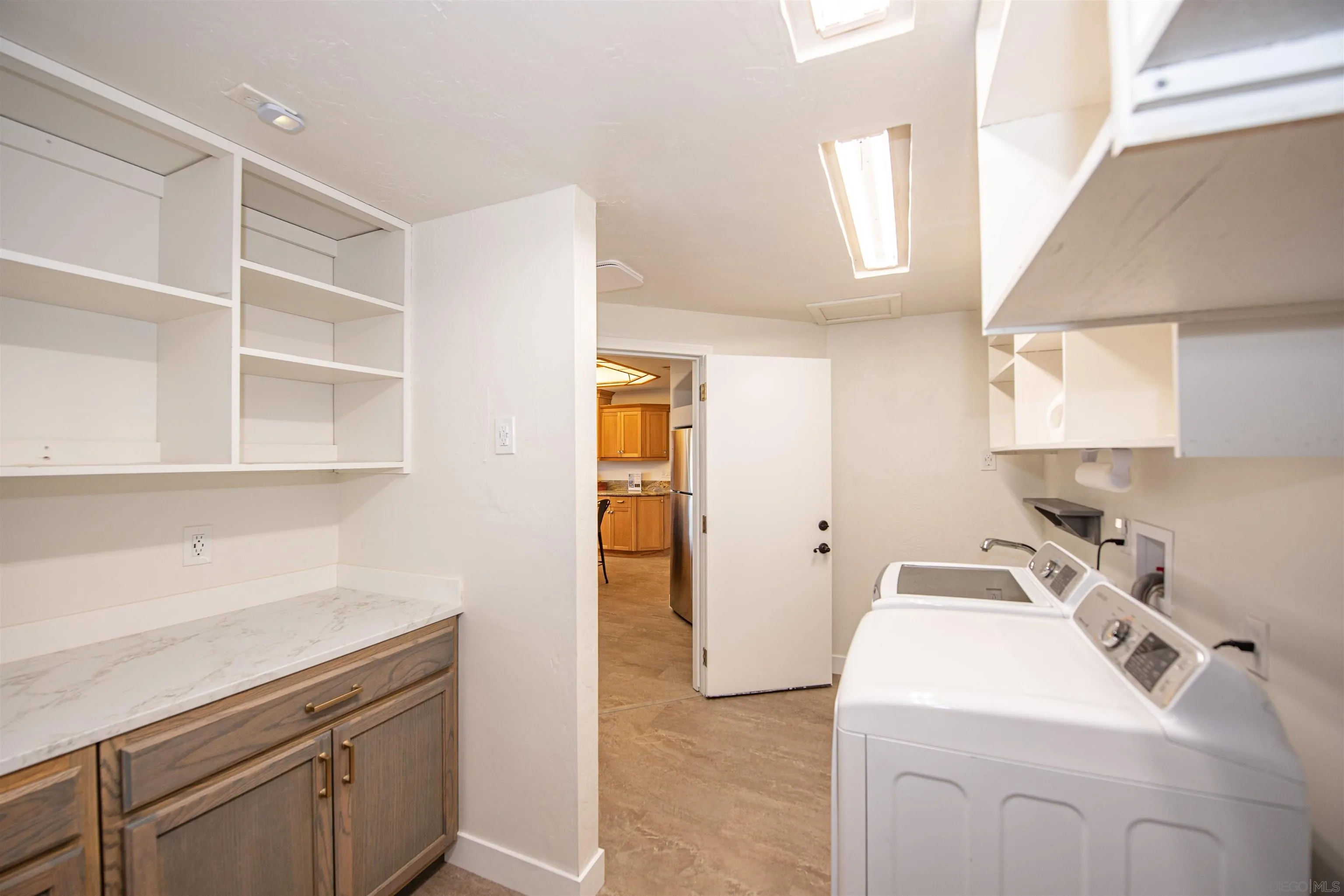 13419 Sebago Avenue Poway, CA 92064 - Photo 16 of 44 a utility room with cabinets washer and dryer