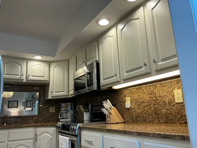 a kitchen with stainless steel appliances granite countertop a sink a stove and cabinets