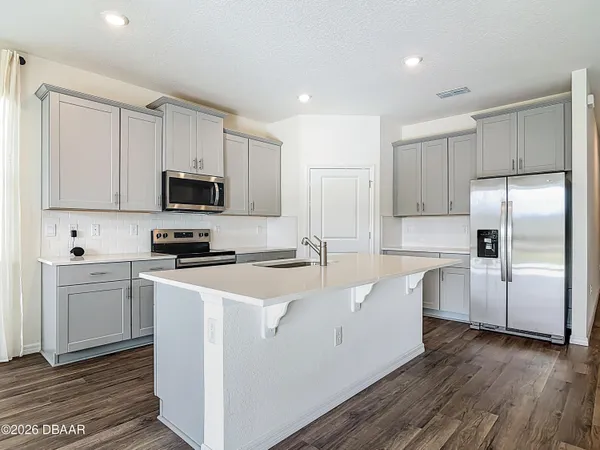 a kitchen with a sink cabinets stainless steel appliances and windows