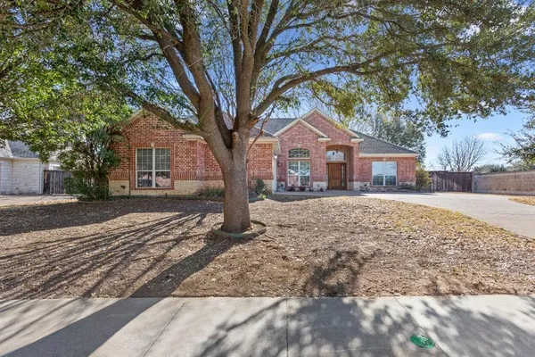 a front view of a house with a yard and large trees