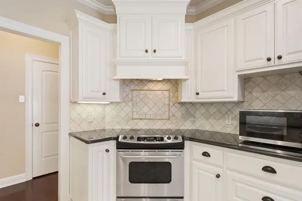 a kitchen with granite countertop white cabinets and white appliances