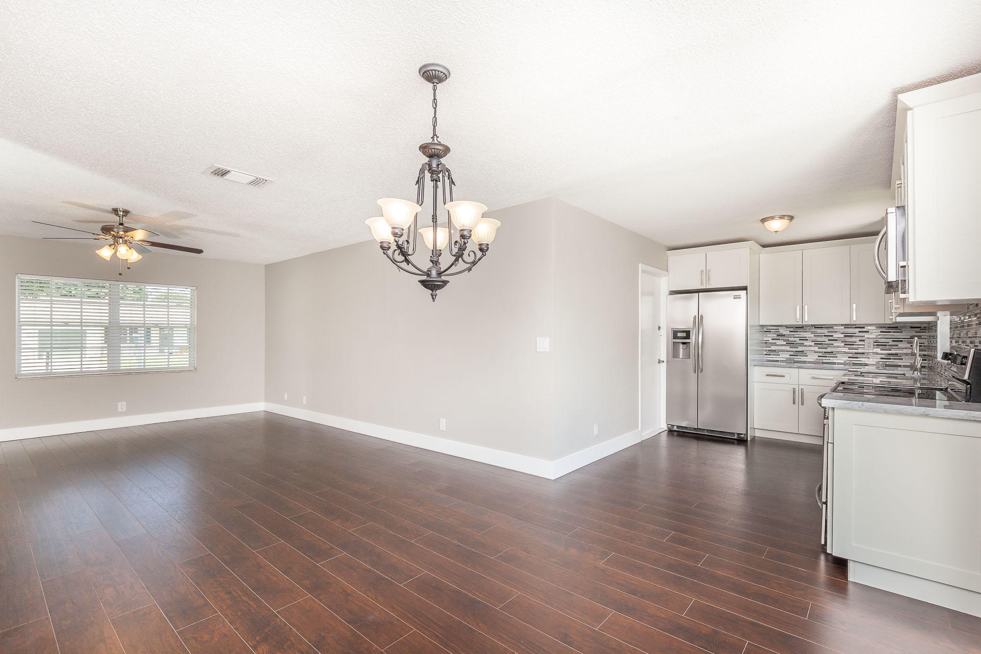 9868 Liberty Road Boca Raton, FL 33434 - Photo 8 of 22 a view of a kitchen with a sink wooden floor and a chandelier
