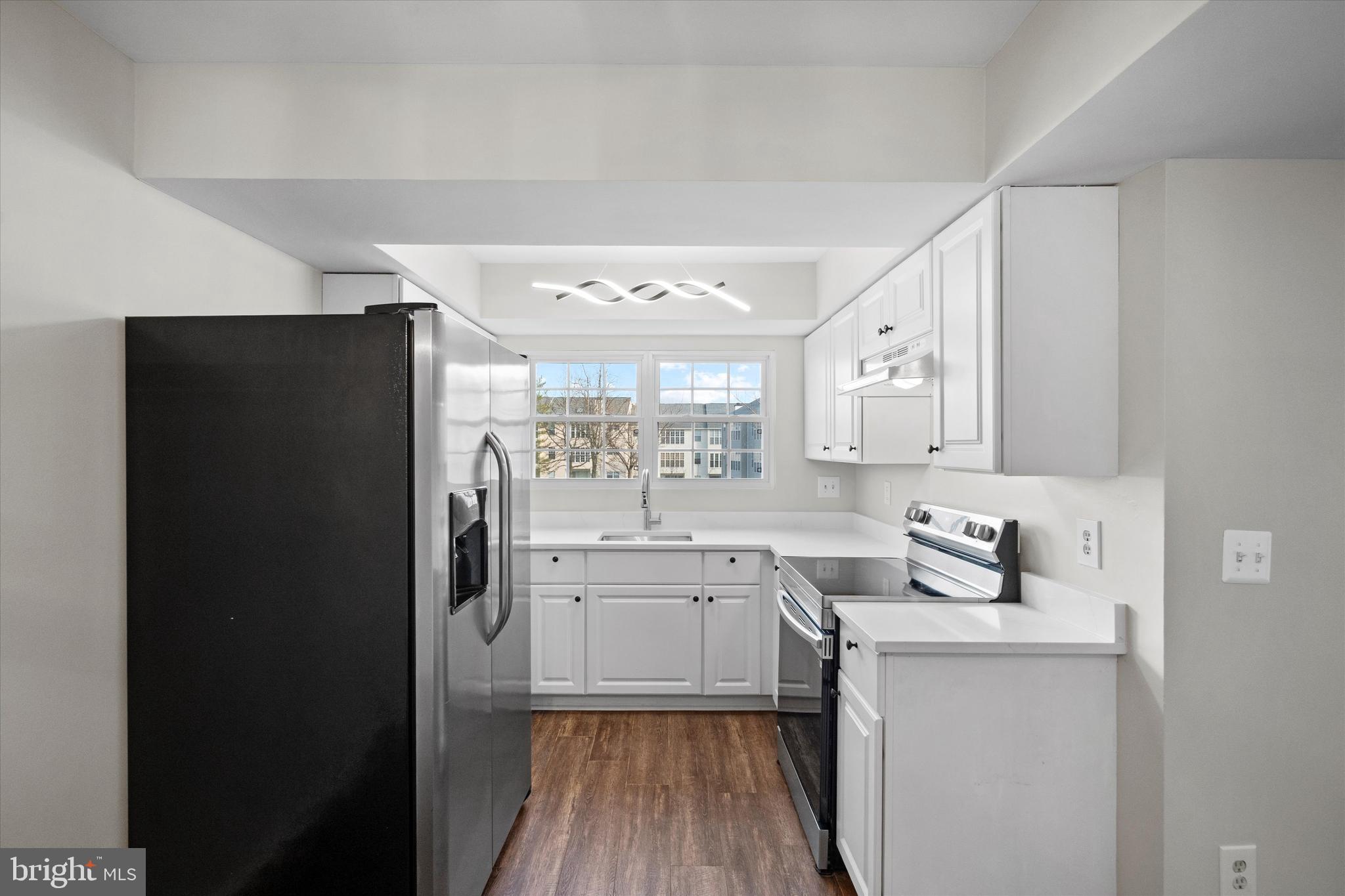 129 Fort Evans Road Southeast, Unit A Leesburg, VA 20175 - Photo 12 of 33 a kitchen with a sink and a refrigerator