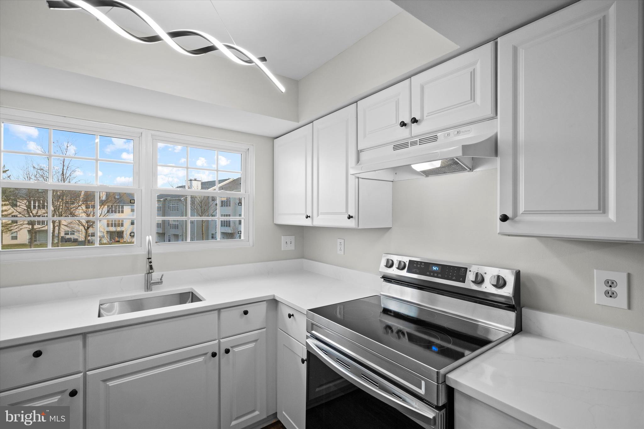 129 Fort Evans Road Southeast, Unit A Leesburg, VA 20175 - Photo 14 of 33 a kitchen with cabinets appliances a sink and a window