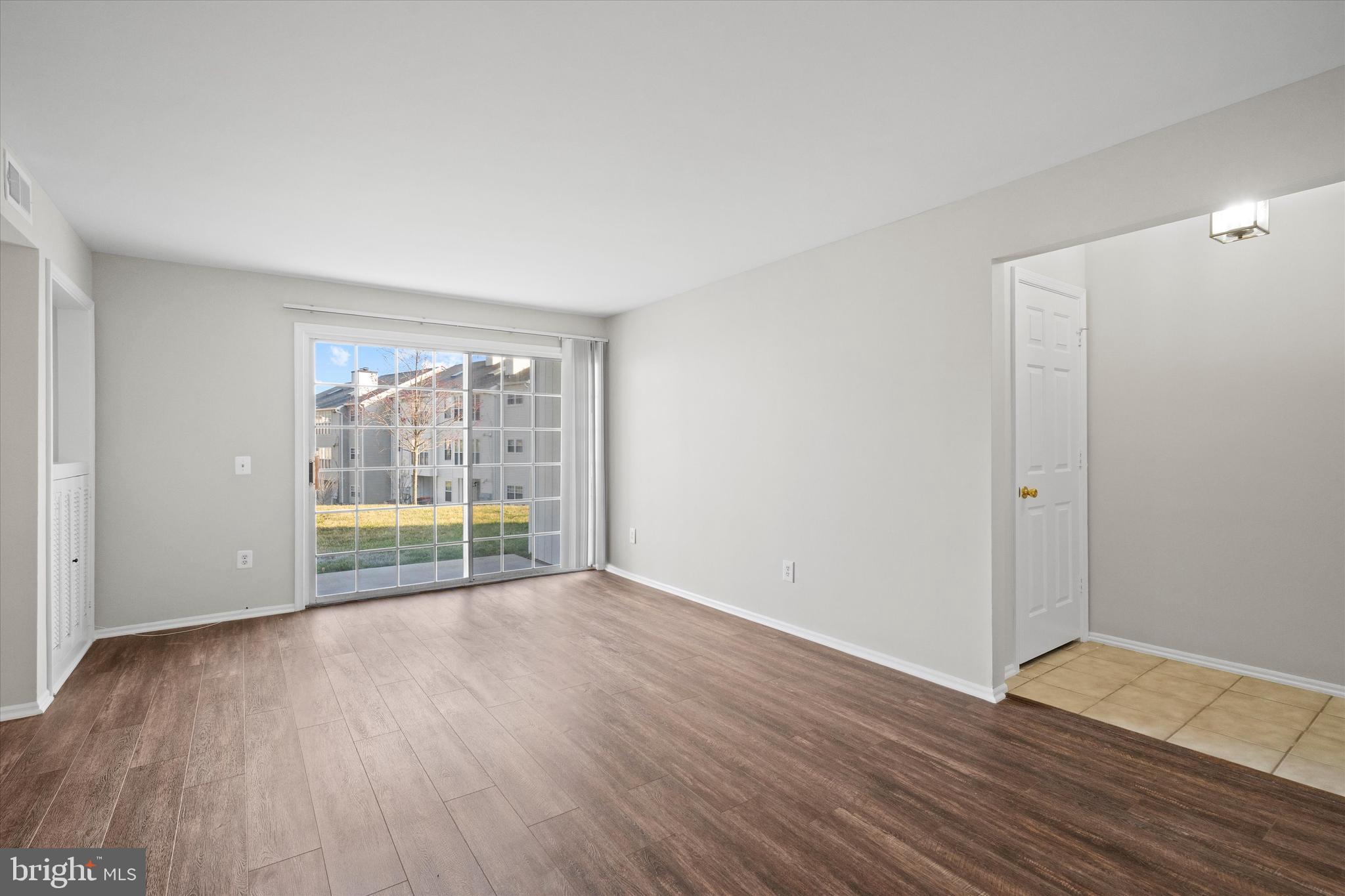 129 Fort Evans Road Southeast, Unit A Leesburg, VA 20175 - Photo 7 of 33 a view of an empty room with wooden floor and a window
