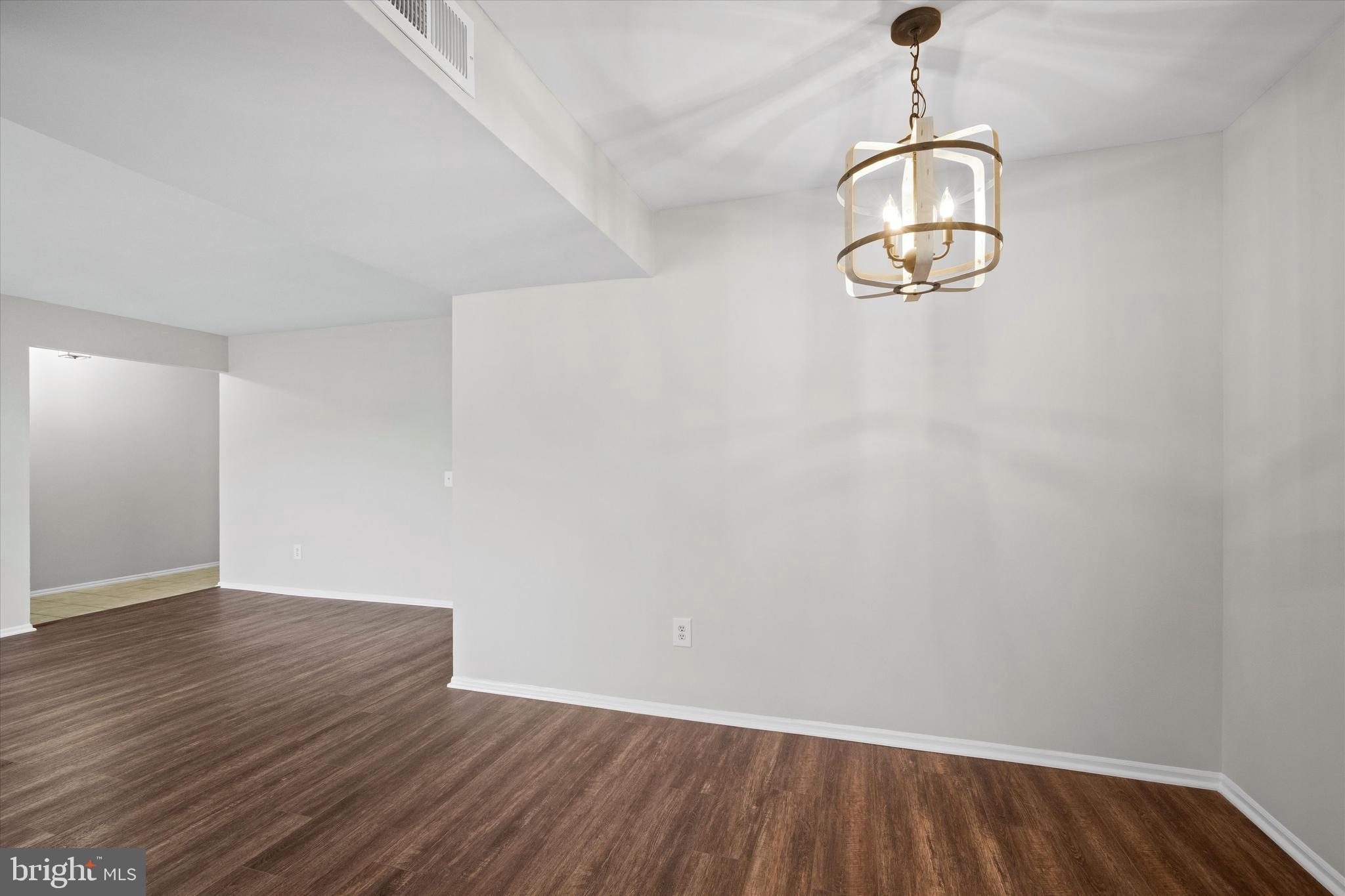 129 Fort Evans Road Southeast, Unit A Leesburg, VA 20175 - Photo 10 of 33 a view of empty room with wooden floor and chandelier