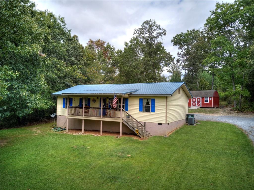 a front view of a house with a garden and trees